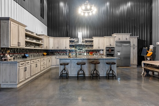 3398 SE 3000, Andrews, TX 79714 - kitchen featuring open shelves, a towering ceiling, stainless steel appliances, concrete floors, and an island with sink