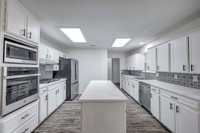 kitchen featuring stainless steel appliances, a center island, and white cabinetry