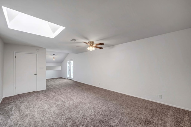 bonus room featuring lofted ceiling with skylight, carpet, visible vents, and a ceiling fan