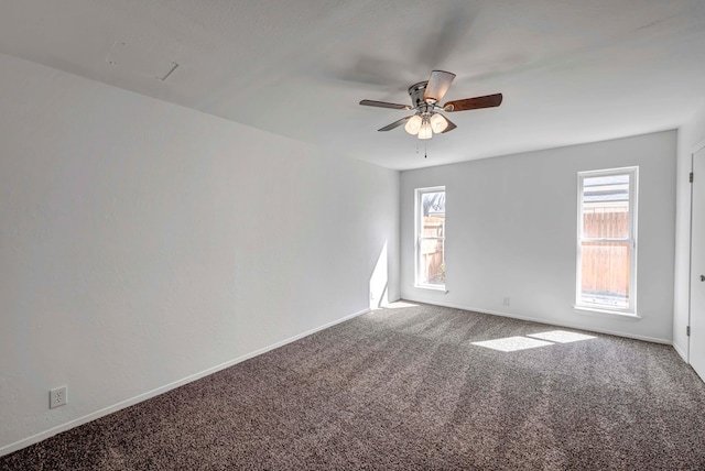 carpeted spare room featuring ceiling fan and baseboards