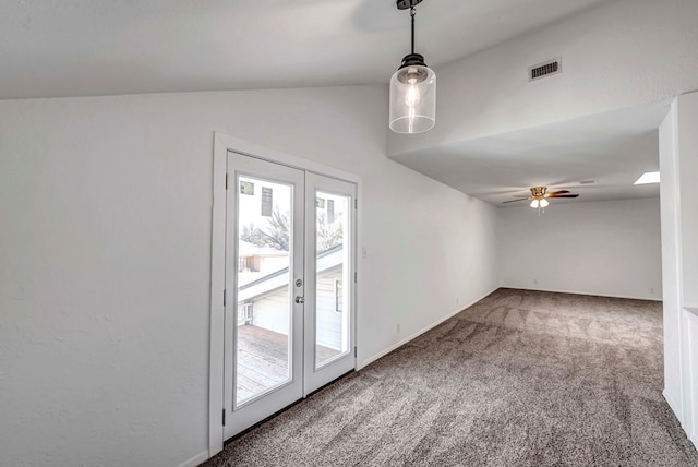 carpeted empty room featuring a ceiling fan, lofted ceiling, french doors, and visible vents