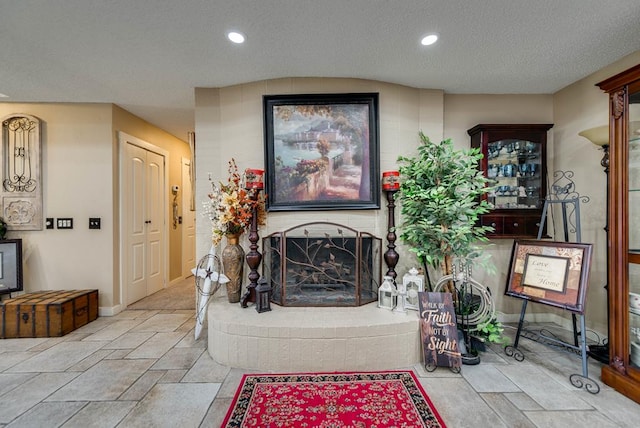 2919 Kirkwood Dr, Odessa, TX 79762 - living room featuring a brick fireplace, a textured ceiling, recessed lighting, and stone finish floors
