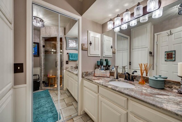 2919 Kirkwood Dr, Odessa, TX 79762 - bathroom featuring a stall shower, vanity, stone tile flooring, and wainscoting