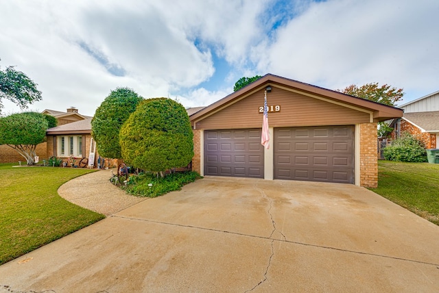 2919 Kirkwood Dr, Odessa, TX 79762 - view of front of home featuring brick siding, a garage, a front lawn, and driveway