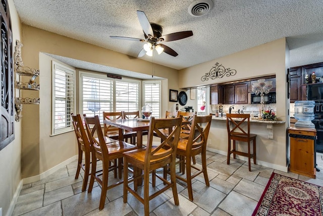 2919 Kirkwood Dr, Odessa, TX 79762 - dining space with ceiling fan, a textured ceiling, and stone tile floors