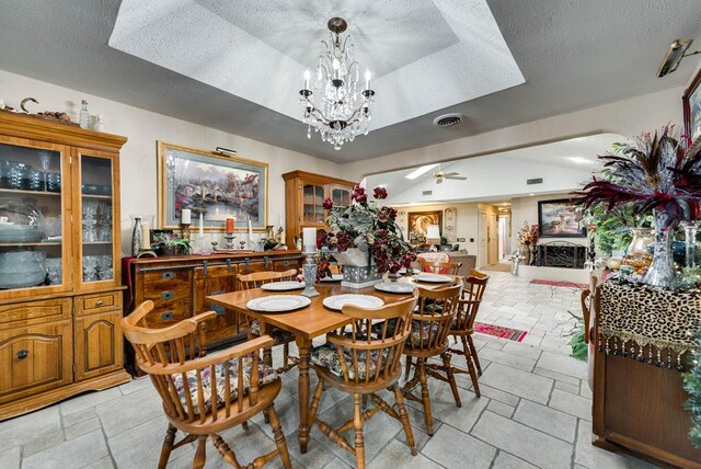 2919 Kirkwood Dr, Odessa, TX 79762 - dining space featuring a tray ceiling, a chandelier, a textured ceiling, and ceiling fan
