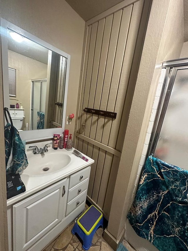 2919 Kirkwood Dr, Odessa, TX 79762 - full bathroom featuring a shower with shower door, vanity, and a textured wall