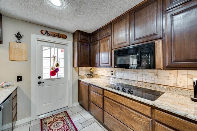 2919 Kirkwood Dr, Odessa, TX 79762 - kitchen featuring black appliances, tasteful backsplash, light stone countertops, and a textured ceiling