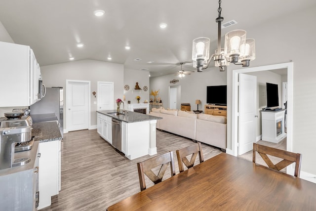kitchen with white cabinetry, visible vents, a sink, and ceiling fan with notable chandelier