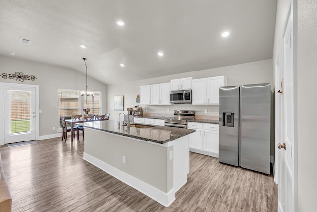 kitchen with a sink, lofted ceiling, light wood-type flooring, white cabinets, and appliances with stainless steel finishes