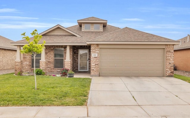 view of front facade with roof with shingles, a front lawn, brick siding, and driveway