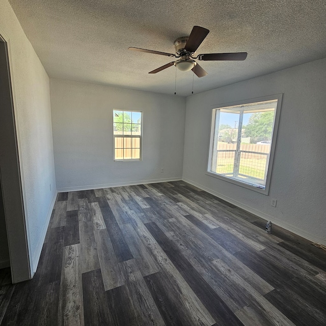 1310 S Emerson Ave, Mccamey, TX 79752 - unfurnished room featuring dark wood-style floors, a textured ceiling, ceiling fan, and baseboards