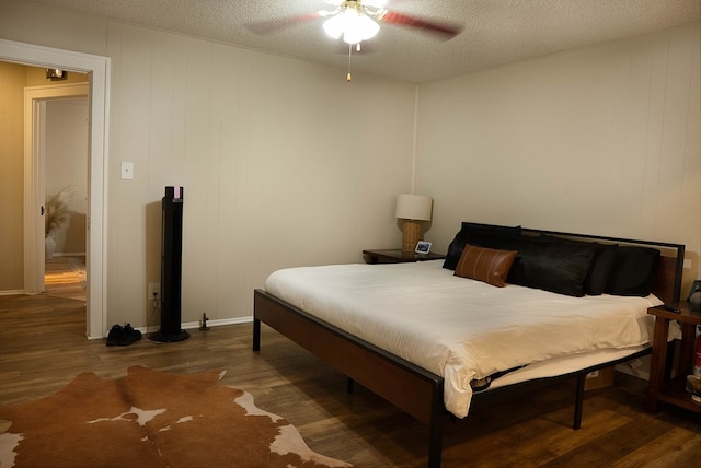 302 County Rd 409, Seminole, TX 79714 - bedroom featuring wood finished floors, a textured ceiling, ceiling fan, and baseboards