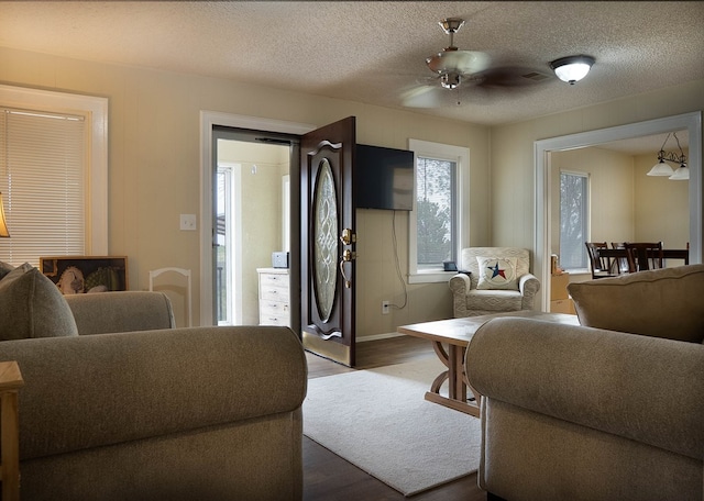 302 County Rd 409, Seminole, TX 79714 - living area with dark wood finished floors, a ceiling fan, a textured ceiling, and baseboards