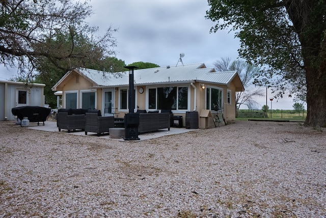 302 County Rd 409, Seminole, TX 79714 - back of property with outdoor lounge area, metal roof, a patio, and stucco siding