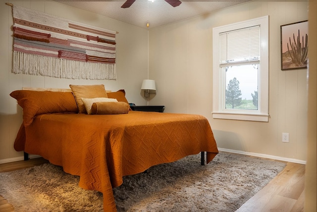 302 County Rd 409, Seminole, TX 79714 - bedroom featuring wood finished floors, baseboards, a ceiling fan, and a textured ceiling