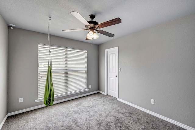unfurnished room with baseboards, carpet flooring, a textured ceiling, and ceiling fan