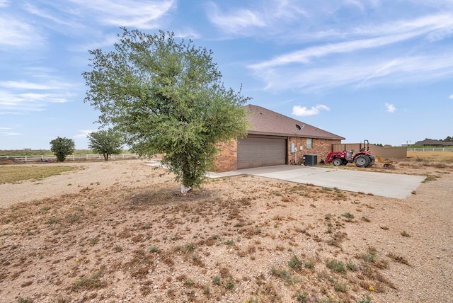 view of front of home with an attached garage, fence, brick siding, and concrete driveway