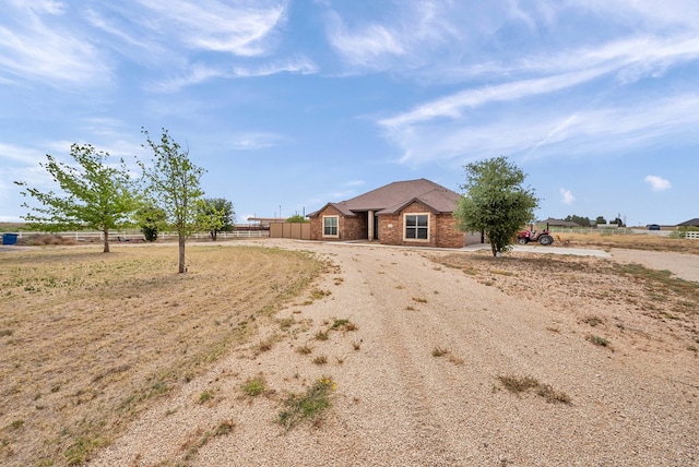 ranch-style house featuring brick siding and fence