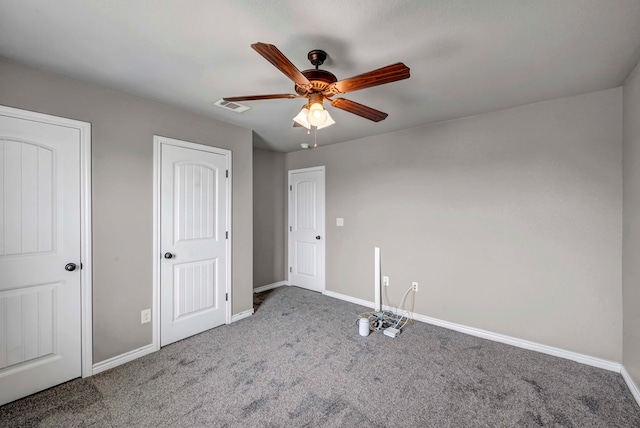 unfurnished bedroom with carpet flooring, baseboards, visible vents, and ceiling fan