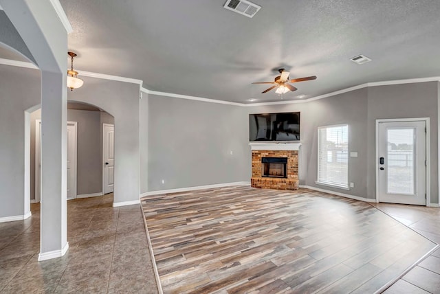 unfurnished living room with arched walkways, ceiling fan, baseboards, and visible vents