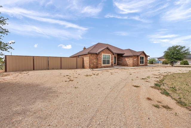single story home with an outbuilding, a shingled roof, and brick siding