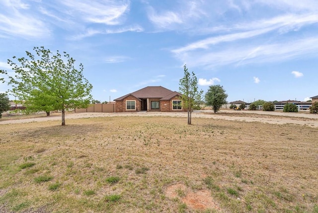 ranch-style home featuring fence