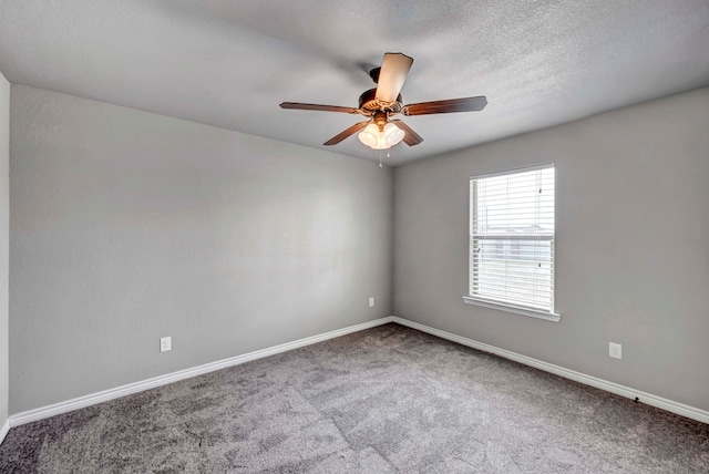 carpeted empty room featuring ceiling fan and baseboards