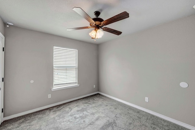 carpeted empty room with baseboards and ceiling fan