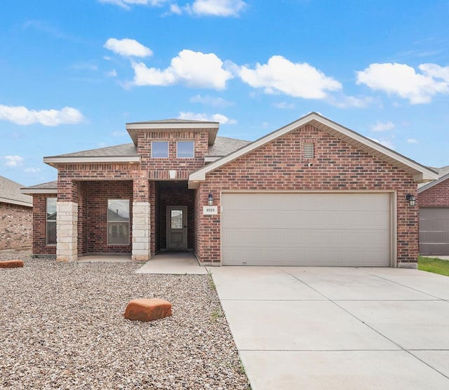 8919 Red Cliff Ave, Odessa, TX 79765 - view of front of house featuring brick siding, an attached garage, driveway, and a shingled roof