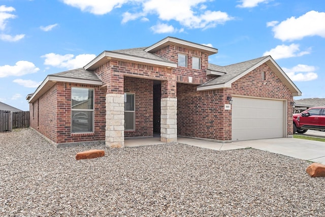 8919 Red Cliff Ave, Odessa, TX 79765 - view of front facade with brick siding, a shingled roof, concrete driveway, and an attached garage