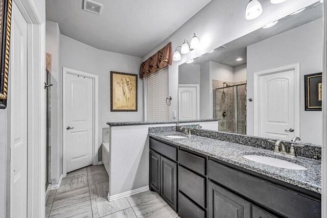 7016 Spur Ranch Rd, Odessa, TX 79765 - bathroom featuring a shower stall, double vanity, a garden tub, and marble look tiles