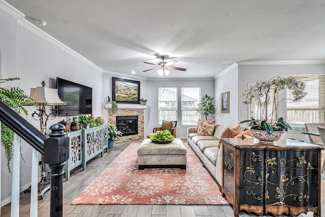 7016 Spur Ranch Rd, Odessa, TX 79765 - living area featuring ceiling fan, ornamental molding, a fireplace, wood finished floors, and a textured ceiling