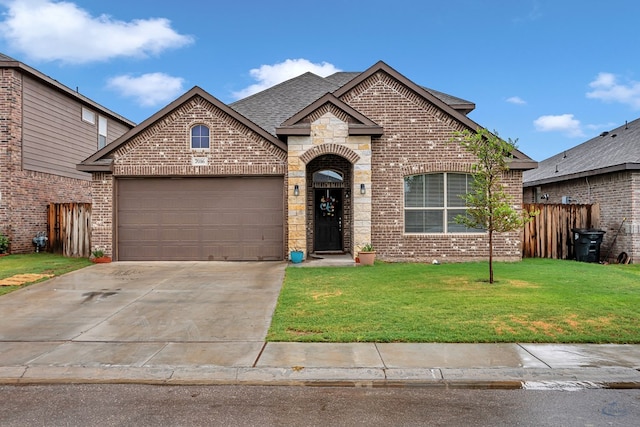 7016 Spur Ranch Rd, Odessa, TX 79765 - french country home with brick siding, a shingled roof, an attached garage, and driveway