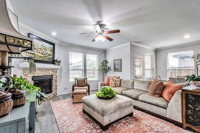 7016 Spur Ranch Rd, Odessa, TX 79765 - living room featuring ceiling fan, a fireplace, wood finished floors, crown molding, and a textured ceiling
