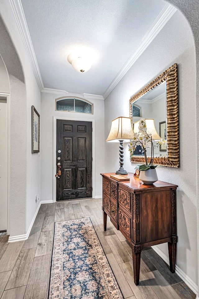 7016 Spur Ranch Rd, Odessa, TX 79765 - entryway featuring wood finished floors, crown molding, arched walkways, and a textured ceiling