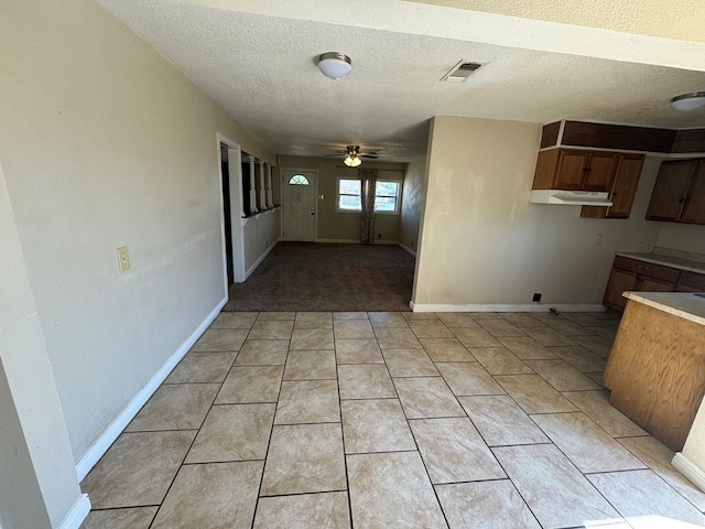 kitchen featuring ceiling fan, light tile patterned floors, and a textured ceiling