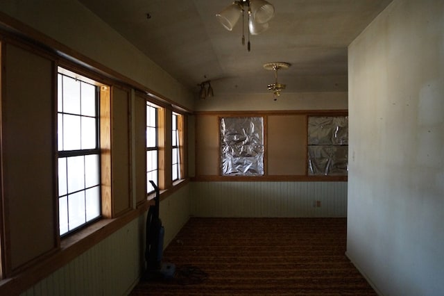 708 W Yukon Rd, Odessa, TX 79764 - corridor featuring vaulted ceiling, carpet flooring, and a wainscoted wall