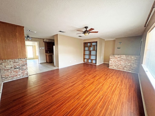 unfurnished living room with ceiling fan, light hardwood / wood-style floors, and a textured ceiling