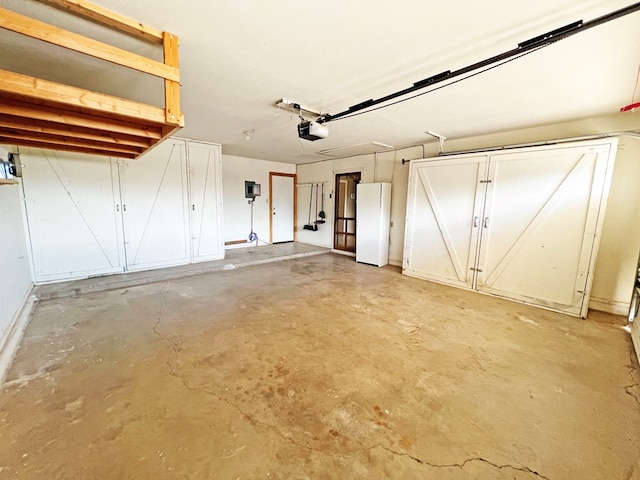 garage with white fridge and a garage door opener