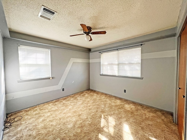 unfurnished bedroom featuring carpet flooring, a textured ceiling, and ceiling fan