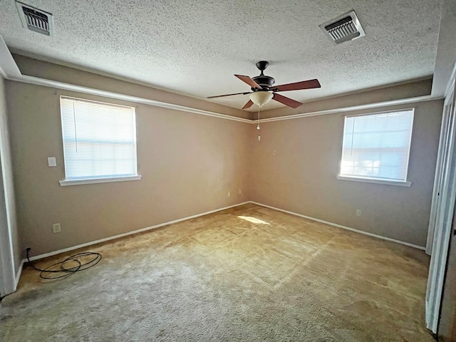 carpeted spare room featuring ceiling fan and a textured ceiling