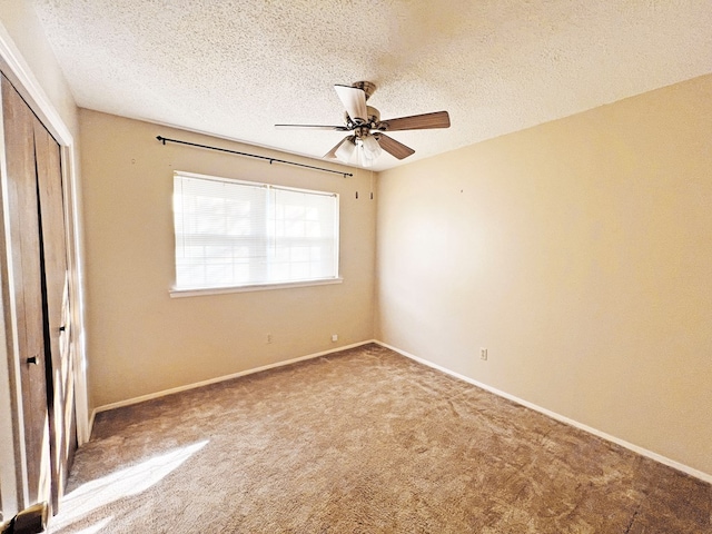 unfurnished bedroom featuring a textured ceiling, carpet floors, a closet, and ceiling fan