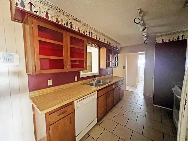 kitchen featuring dishwasher, stove, rail lighting, sink, and a textured ceiling