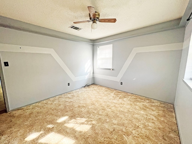 spare room featuring a textured ceiling, carpet floors, and ceiling fan