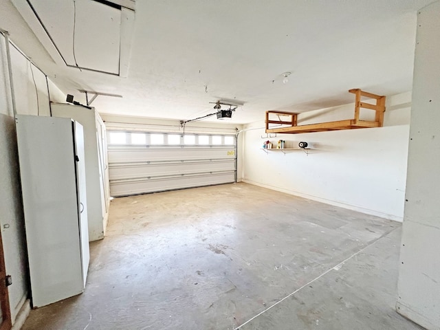 garage featuring white fridge and a garage door opener