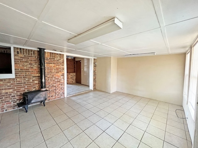 interior space featuring a wood stove and brick wall