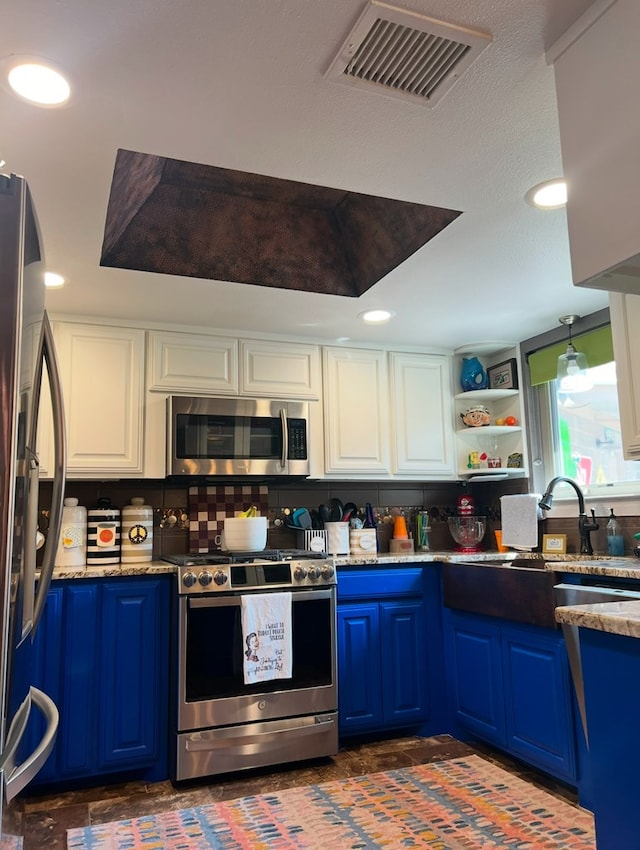 kitchen with blue cabinets, white cabinets, and appliances with stainless steel finishes