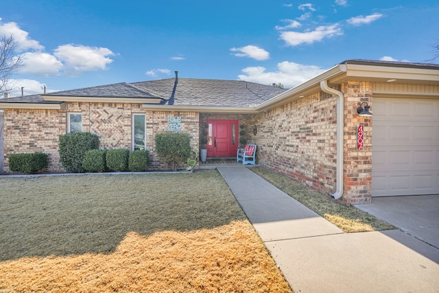 property entrance with brick siding, a lawn, and an attached garage