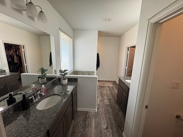 7001 La Escalera Ct, Odessa, TX 79765 - full bath featuring wood finished floors, two vanities, and a spacious closet